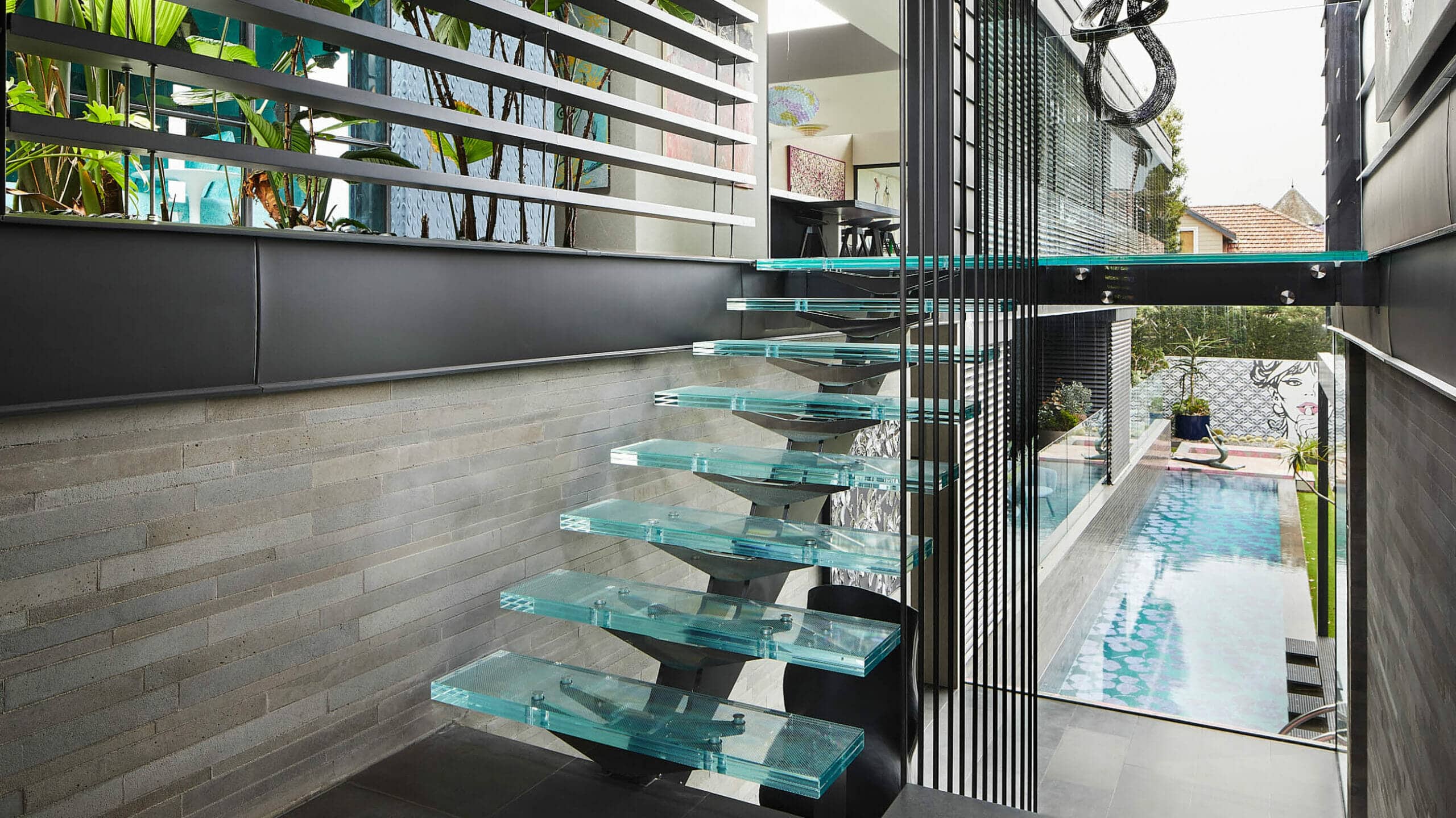Custom-Glass-Staircase-and-Landing-Outlook-of-Pool-and-landscaped-Garden-Tilt-Industrial-Design